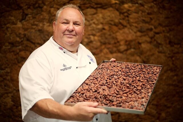 A person holding a tray of beans

Description automatically generated