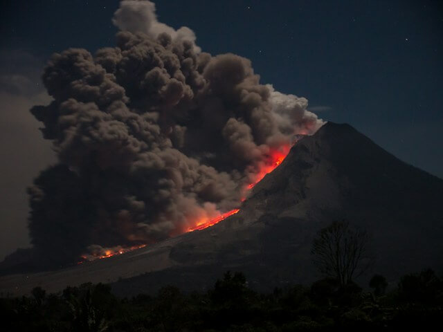A mountain with smoke and fireDescription automatically generated