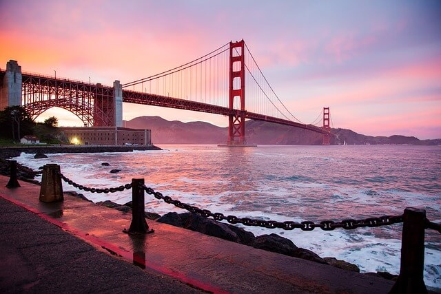 Golden Gate Bridge over water with a pink sky

Description automatically generated