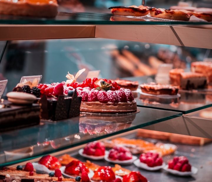 strawberry and blackberry on clear glass display counter