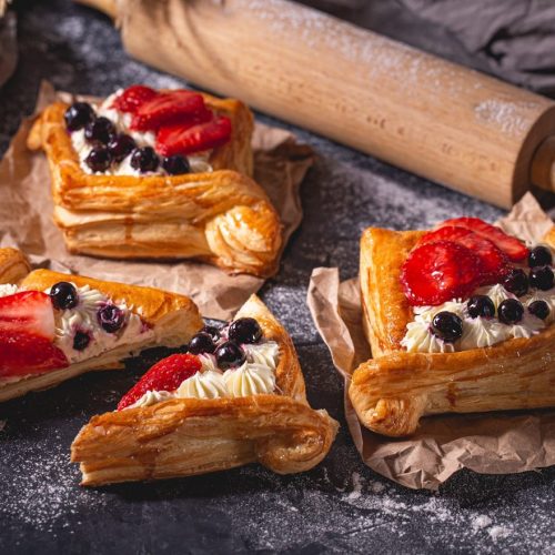 four pastries with strawberries and blueberries on them